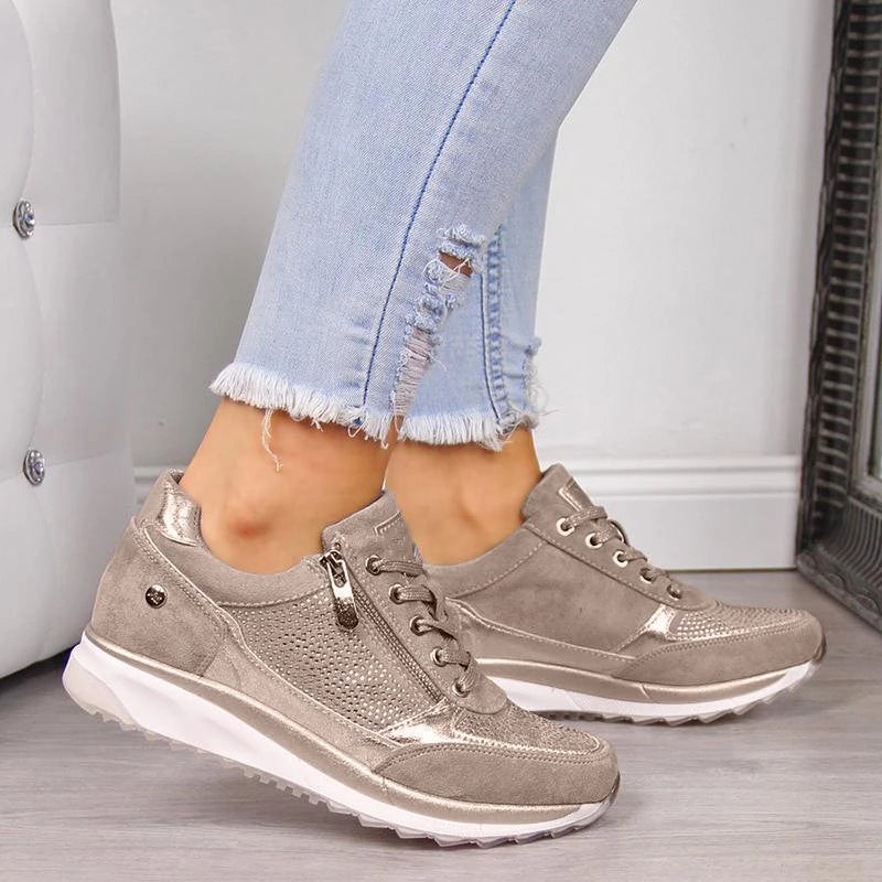 Baskets confortables couleur taupe avec détails perforés, fermeture à lacets et semelle blanche épaisse, parfaites pour un usage quotidien et un style tendance.