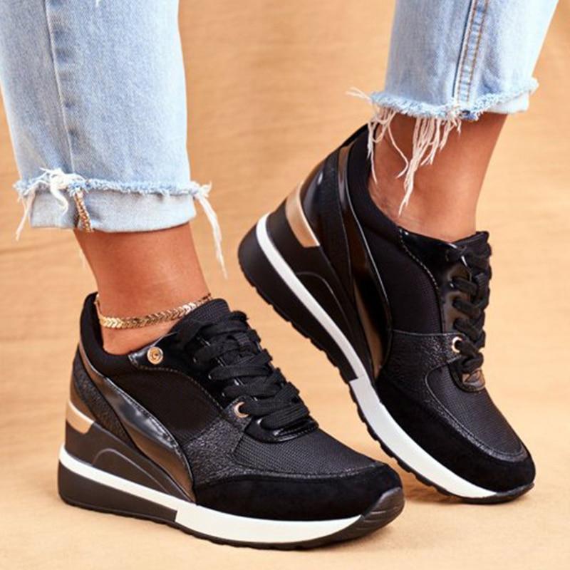 Baskets noires élégantes avec des accents dorés, dotées d'une semelle à talon ergonomique épurée, conçues pour le confort et l'élégance. Les chaussures sont associées à un jean bleu déchiré, ajoutant une touche chic et décontractée, idéale pour un look quotidien.