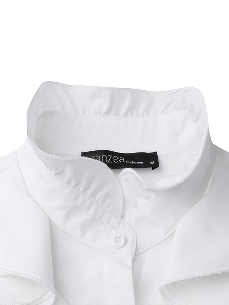 Gros plan sur le col élégant du chemisier blanc, doté d’un bouton discret et d’une finition soignée pour un style raffiné et moderne.