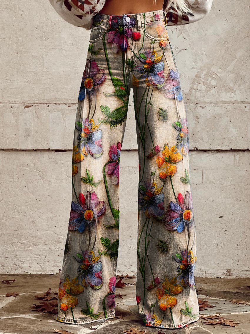Jeans à taille haute et coupe large pour femmes, imprimés de fleurs, avec un mélange de fleurs et de feuilles vibrantes sur un fond beige, idéals pour des looks décontractés et sportifs.
