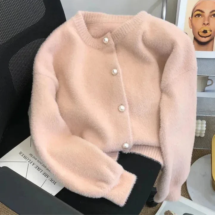 Cardigan chic pour femme Luna avec des boutons en perles élégants, posé sur un bureau avec un fond moderne, parfait pour une tenue décontractée et raffinée.