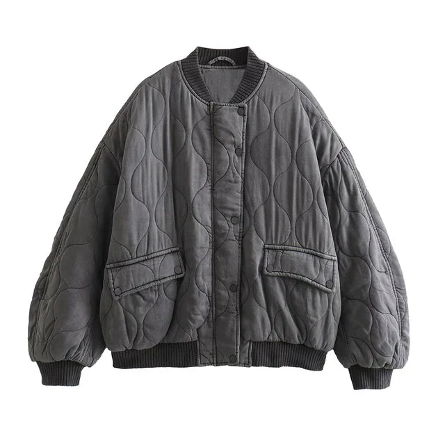 Blouson long gris "Nancy" pour femme avec un design matelassé, poches latérales et bord-côte au niveau des poignets et du bas, pour un look décontracté et tendance.