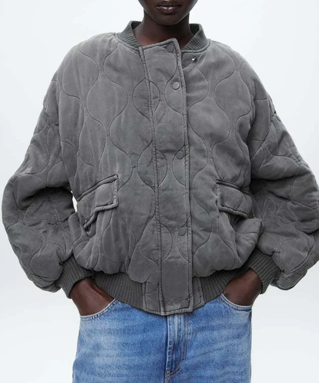 Blouson long gris "Nancy" pour femme avec un design matelassé et des poches latérales, offrant une coupe décontractée et un style urbain, idéal pour une tenue casual-chic.