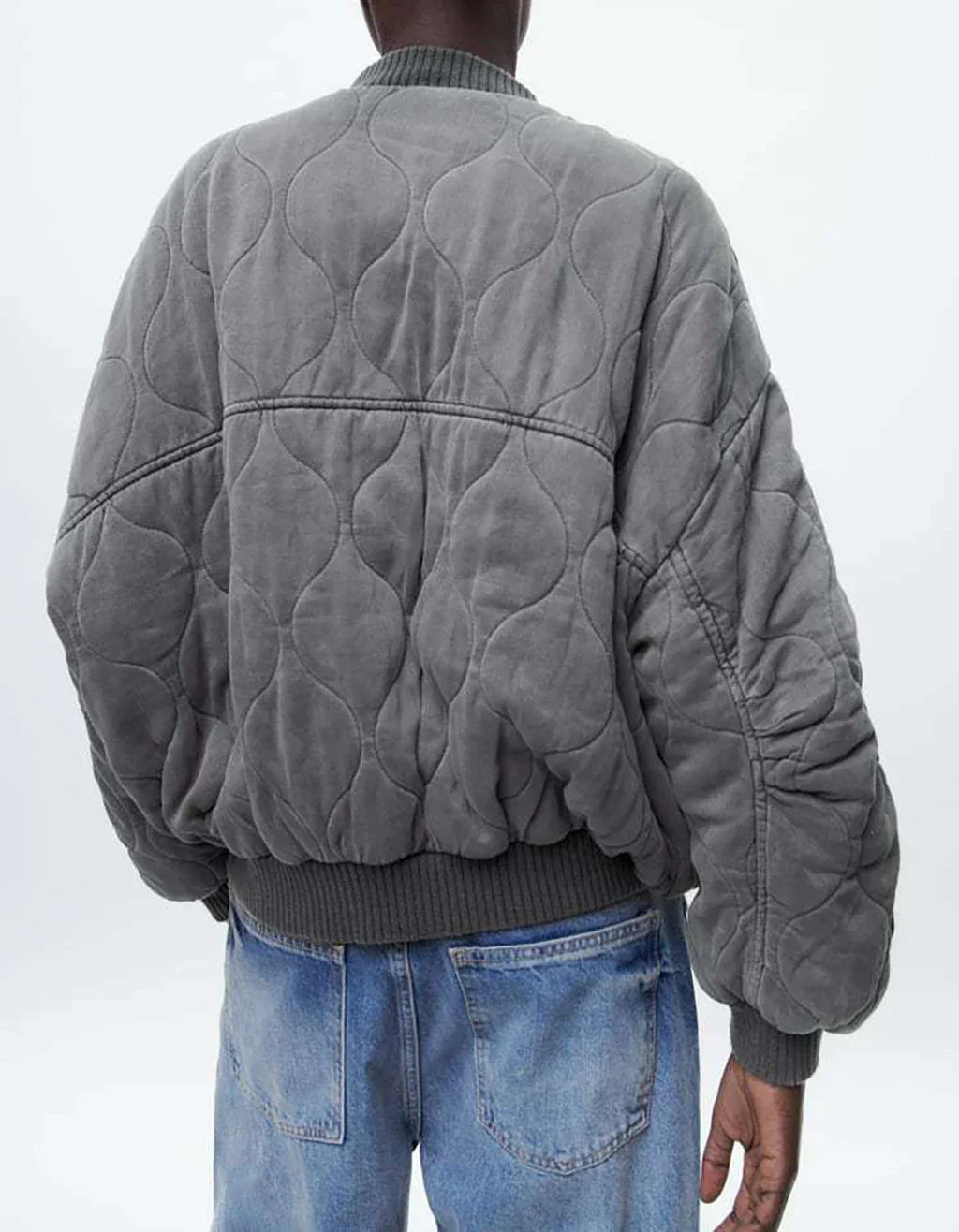 Vue arrière du blouson long gris "Nancy" pour femme avec un design matelassé moderne et des bords côtelés, offrant une silhouette décontractée et confortable, idéale pour un style casual-chic.