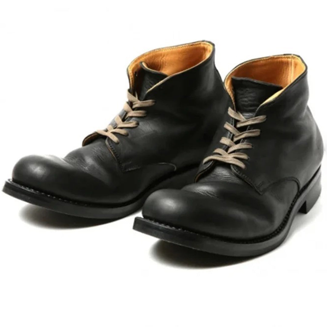 Un gros plan sur une paire de bottes hautes en cuir noir pour homme, avec des lacets beiges, un design épuré à bout rond et un intérieur lisse de couleur moutarde, parfaites pour un style raffiné et classique.