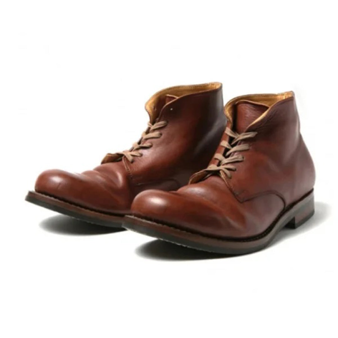 Une paire de bottes hautes en cuir marron pour homme, présentant une finition polie avec des lacets beiges, des orteils ronds et une semelle robuste, offrant un design raffiné et intemporel pour un look élégant et classique.