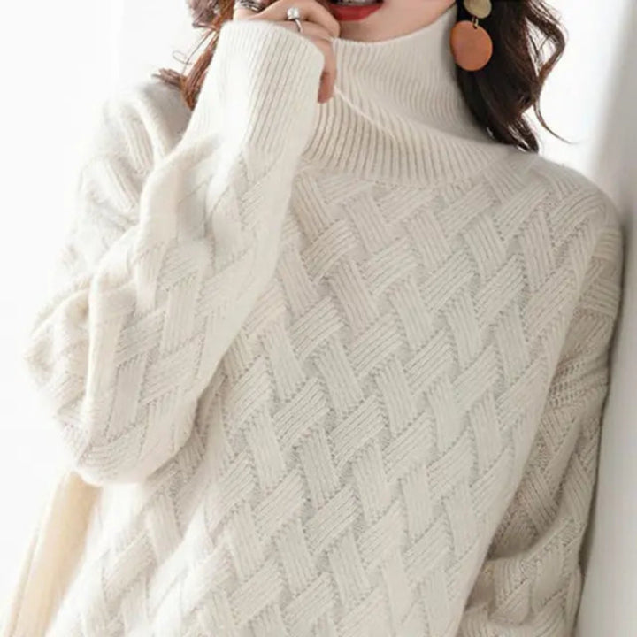 Pull Erminie col roulé tricot tressé pour femme, texturé adapté aux tenues automnales.