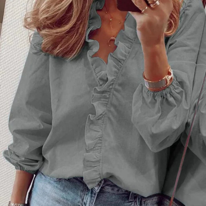 Blouse à volants pour femme, col V élégant et coupe fluide adaptée aux tenues raffinées.