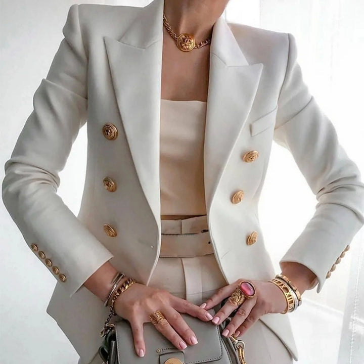 Blazer à boutons dorés pour femme, coupe structurée et détails distinctifs adaptés aux tenues habillées.