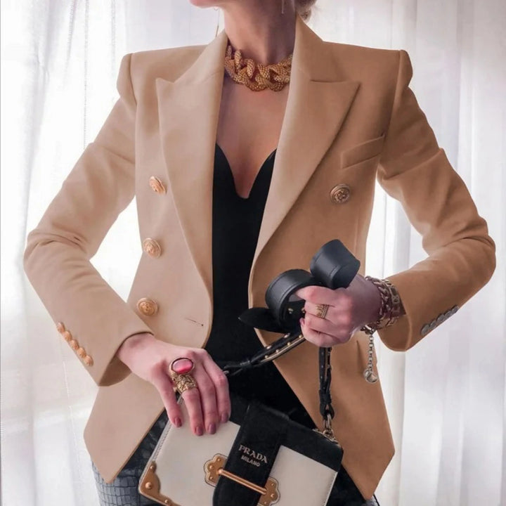 Blazer à boutons dorés pour femme, coupe structurée et détails distinctifs adaptés aux tenues habillées.