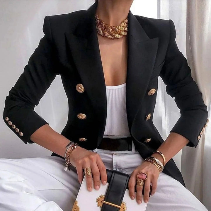 Blazer à boutons dorés pour femme, coupe structurée et détails distinctifs adaptés aux tenues habillées.
