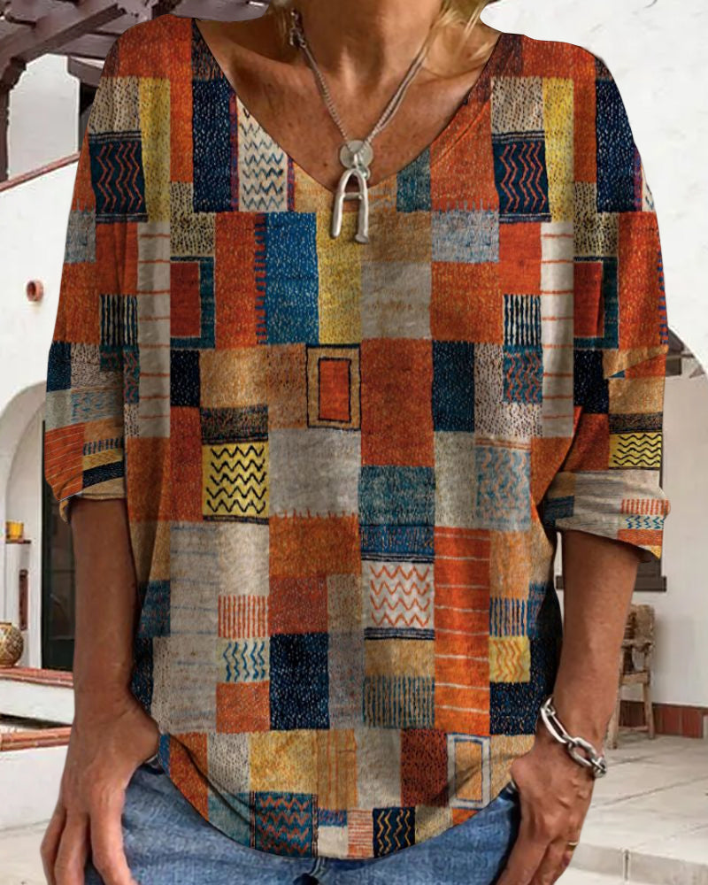 Un haut léger à manches longues pour femme, avec un design coloré et moderne de formes géométriques dans des tons de bleu, orange, jaune et beige, parfait pour l'été. Il est élégant et confortable, idéal pour un look tendance.