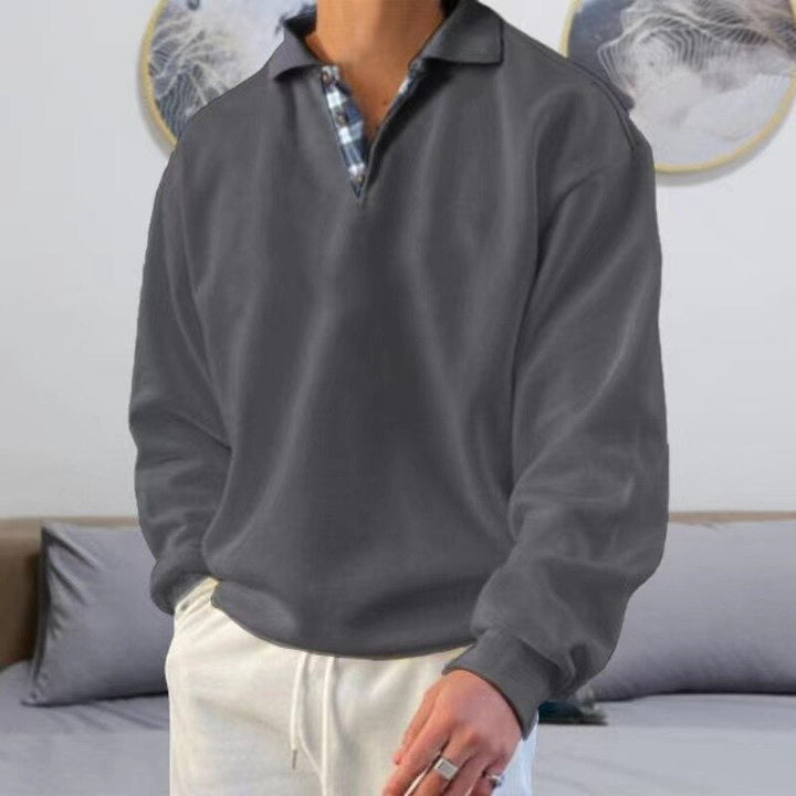 Pull léger à manches longues pour homme, de couleur grise avec un col polo à motif carreaux. Ce modèle moderne et élégant est parfait pour un look décontracté et confortable, idéal pour les journées d'été.
