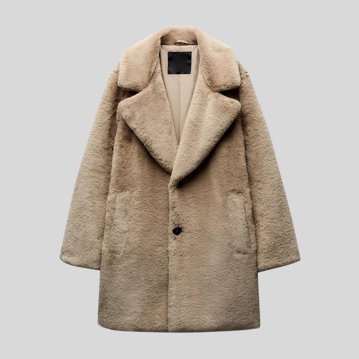 Manteau d'hiver marron pour femme en fausse fourrure douce et moelleuse. Coupe longue et droite, col cranté large. Deux poches latérales discrètes et fermeture boutonnée sur le devant. Confortable et élégant, ce manteau est idéal pour affronter le froid avec style.
