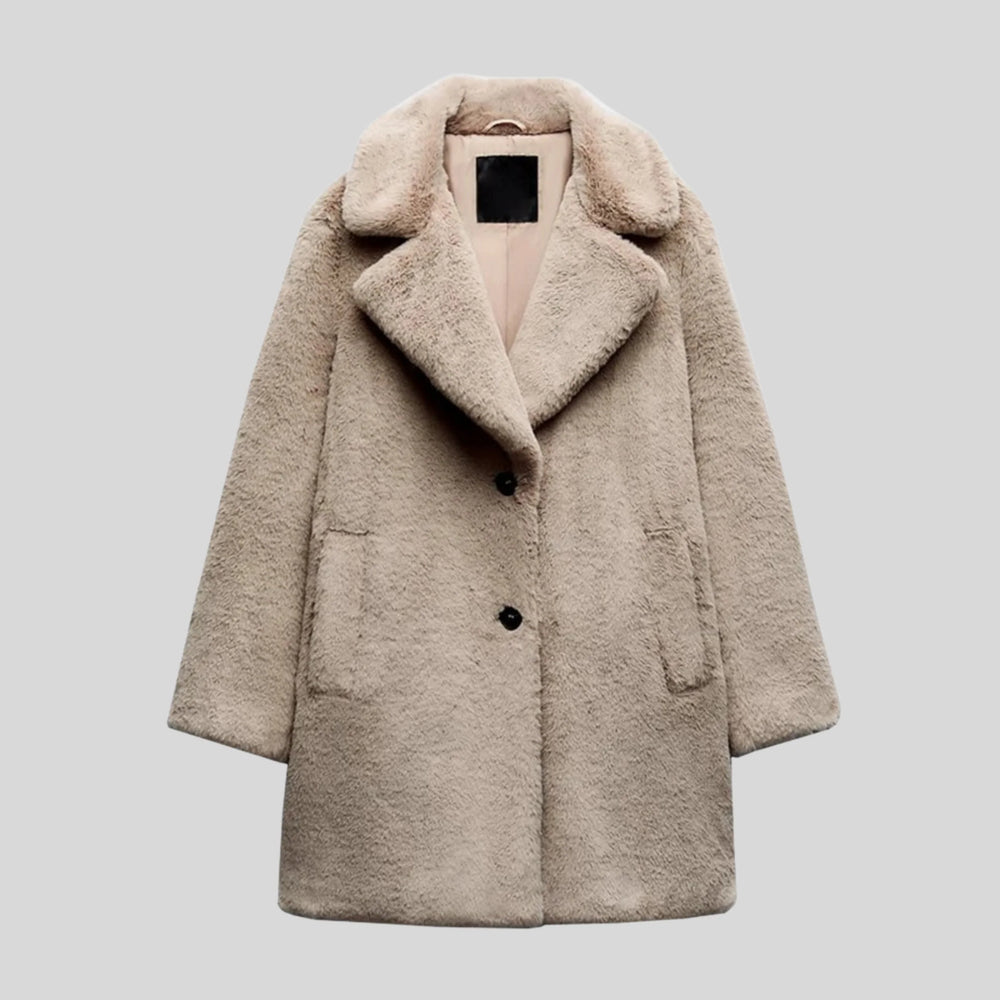 Manteau d'hiver gris en fausse fourrure pour femme, élégant et confortable. Ce long manteau présente une coupe droite, un grand col cranté et deux poches latérales discrètes. Il se ferme sur le devant par deux boutons noirs et offre chaleur et douceur pour affronter le froid avec style.