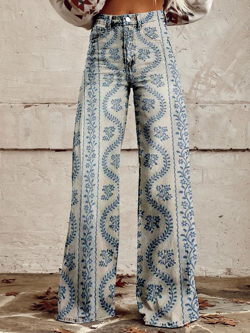 Jean ample pour femme Anouk taille haute, denim clair à imprimé bleu motif floral ondulé, coupe large et jambes évasées, porté devant un mur en béton.
