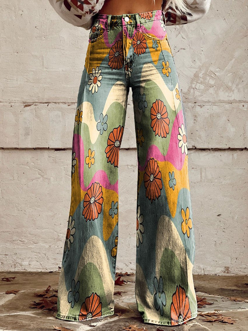 Jean ample pour femme Anouk taille haute, denim multicolore à motifs fleurs rétro et vagues, coupe large et jambes évasées, porté devant un mur en béton.