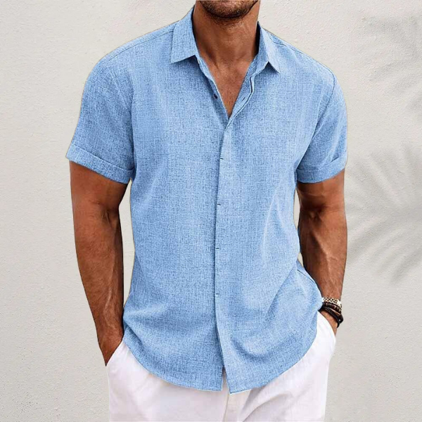 Chemise en lin moderne pour homme, modèle Antoine, de couleur bleu ciel, à manches courtes, coupe ajustée, idéale pour un look estival élégant et décontracté avec un pantalon clair.