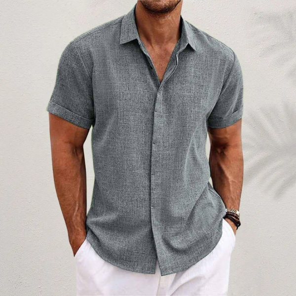 Chemise en lin moderne pour homme, modèle Antoine, de couleur gris clair, à manches courtes, coupe ajustée, idéale pour un style élégant et décontracté avec un pantalon clair.