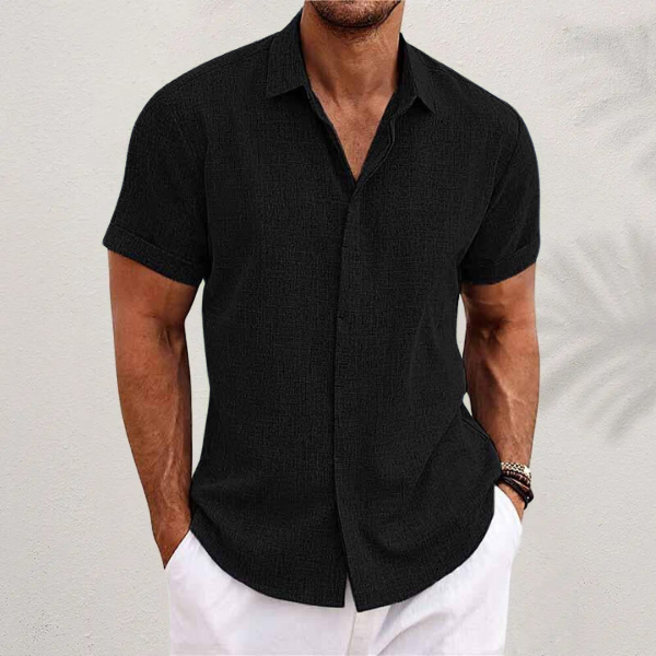 Chemise en lin moderne pour homme, modèle Antoine, de couleur noire, à manches courtes, coupe ajustée, idéale pour un look élégant et décontracté avec un pantalon clair.