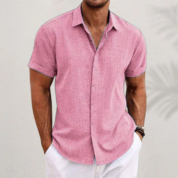 Chemise en lin moderne pour homme, modèle Antoine, de couleur rose, à manches courtes, coupe ajustée, parfaite pour un style estival chic et décontracté avec un pantalon clair.