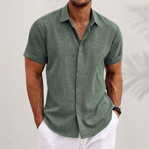 Chemise en lin moderne pour homme, modèle Antoine, de couleur vert olive, à manches courtes, coupe ajustée, idéale pour un look élégant et décontracté avec un pantalon clair.