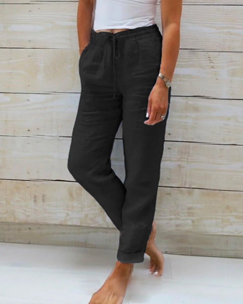 Pantalon noir pour femme avec une taille élastiquée et un cordon de serrage, offrant une coupe décontractée et confortable. Idéal pour un look moderne et élégant, parfait pour une tenue quotidienne stylée et facile à porter.