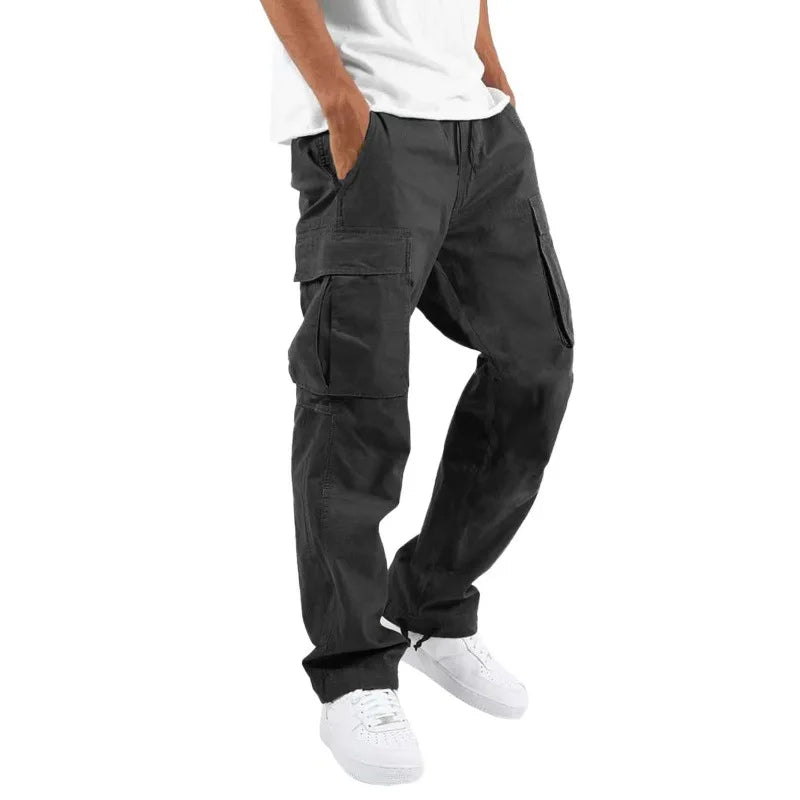 Pantalon droit homme Arsène tendance style cargo en coton noir, avec poches latérales, porté avec un t-shirt blanc et des baskets blanches, sur fond clair.