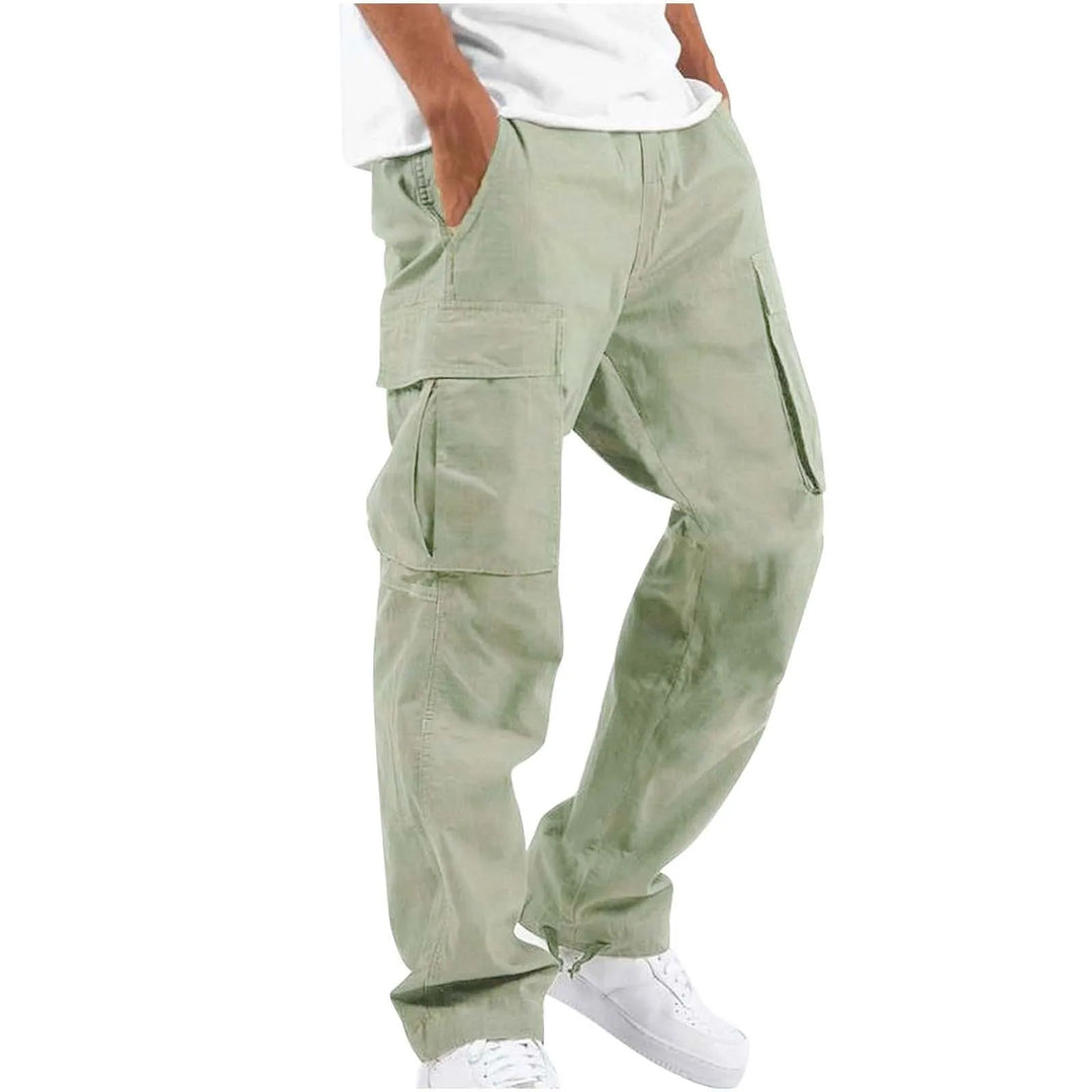 Pantalon droit homme Arsène tendance style cargo en coton vert clair, avec poches latérales, porté avec un t-shirt blanc et des baskets blanches, sur fond clair.