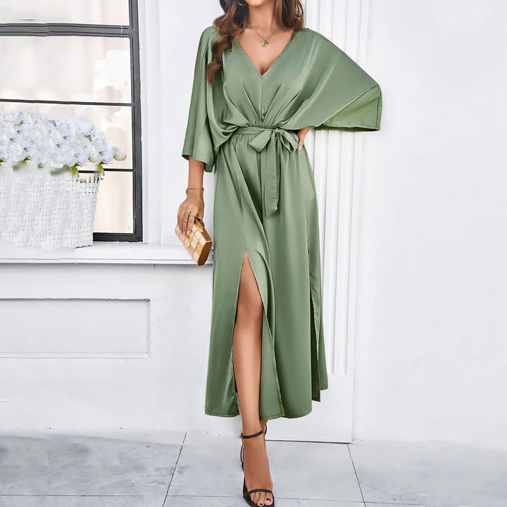 Robe midi Audrey à col en V pour femme, idéale pour l'automne. Sa coupe fluide et élégante avec une fente sur le côté et un lien à la taille, offre une silhouette chic et moderne. Disponible en vert tendre, cette robe tendance allie confort et style, parfaite pour des occasions spéciales ou des sorties estivales.