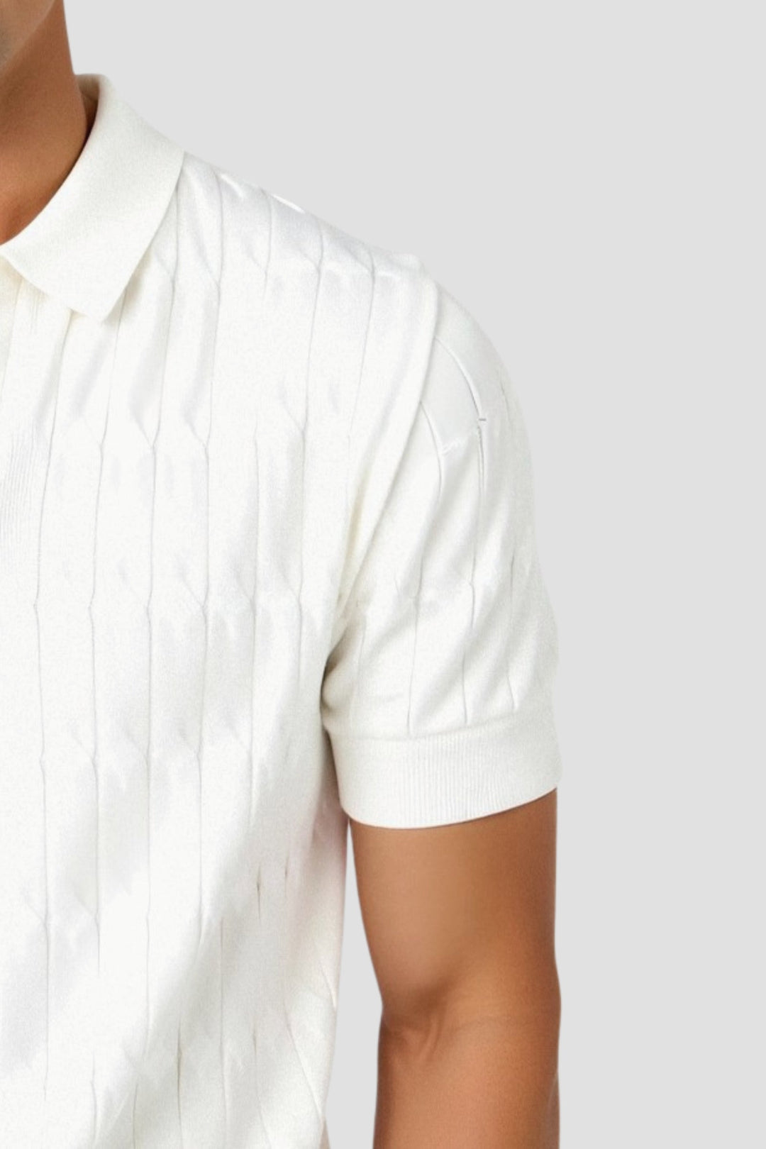 Détail du polo homme blanc, mettant en avant le col classique et la texture subtile du tissu avec un motif raffiné. Les bords côtelés des manches ajoutent une touche élégante, tout en garantissant confort et style. Ce modèle est parfait pour un look sophistiqué et décontracté.