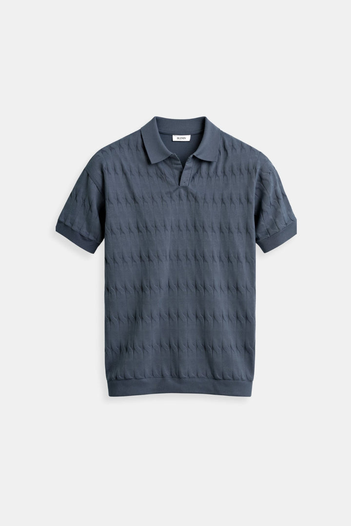 Polo homme de couleur bleu foncé, au design moderne et épuré. Il dispose d'un col classique et d'un motif subtil sur l'ensemble du tissu pour un look raffiné. Idéal pour une tenue décontractée ou semi-formelle, ce polo allie confort et élégance. Parfait pour ceux qui recherchent un style simple mais élégant.
