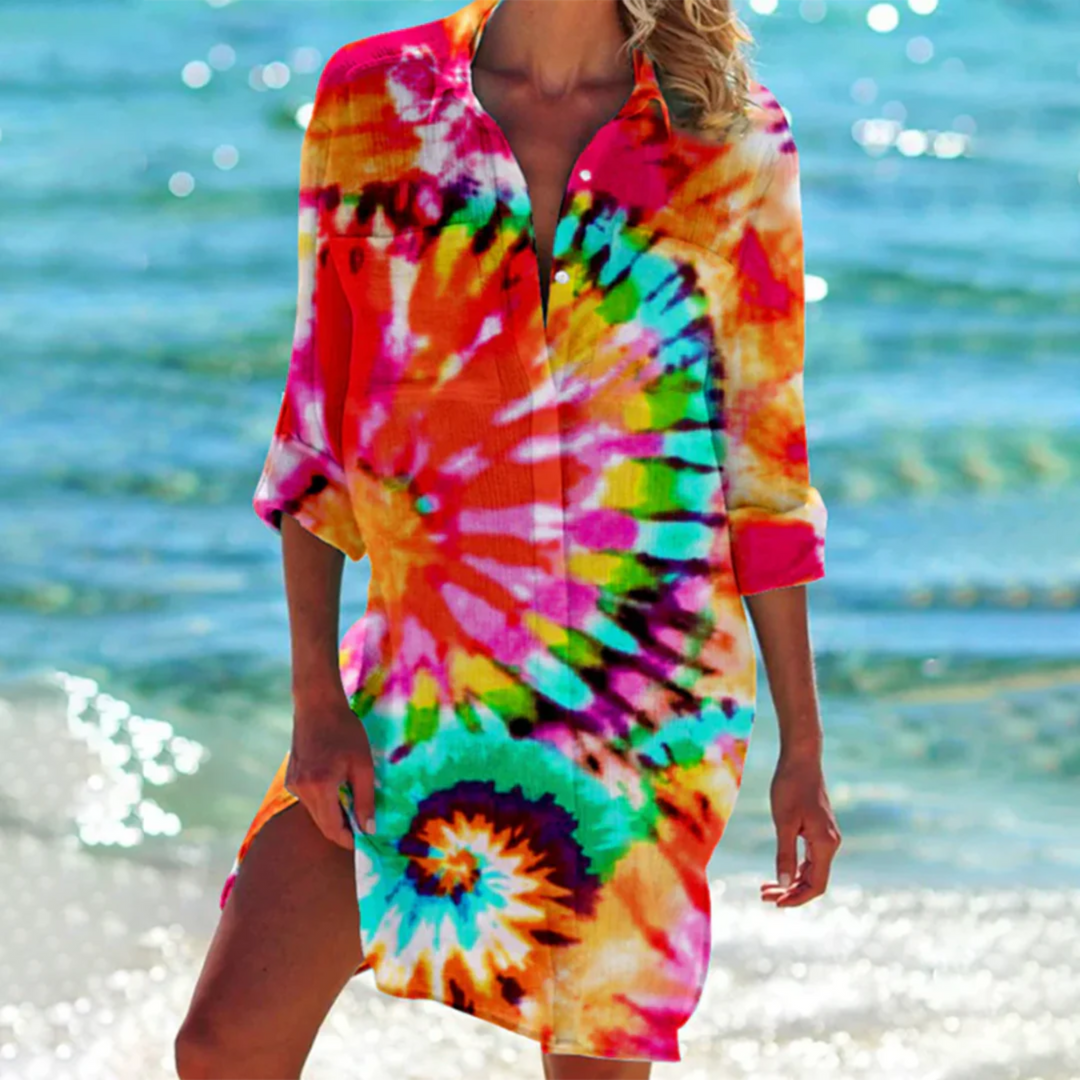 Son design tie-dye vibrant avec des nuances de rouge, bleu, vert et jaune en fait un choix parfait pour une journée ensoleillée à la plage.