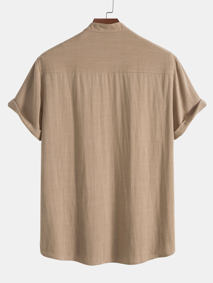 Chemise d'été élégante et légère de couleur beige, avec des manches courtes roulées et un col minimaliste. Un choix parfait pour un look décontracté et stylé pendant les journées chaudes.