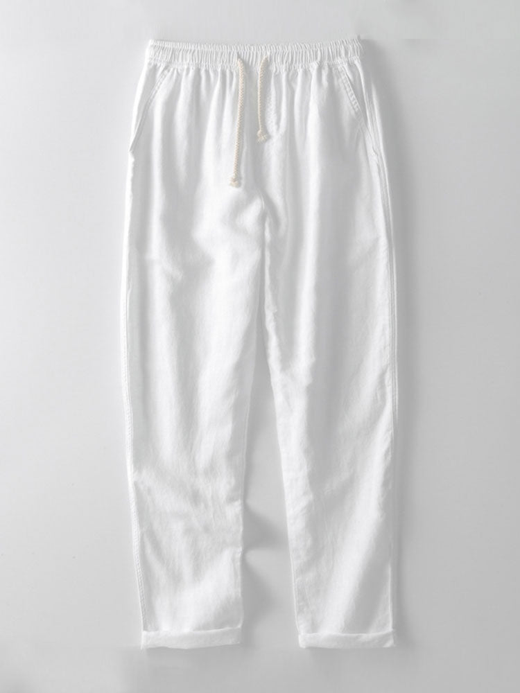 Pantalon d'été léger et confortable de couleur blanche, avec une taille élastique et des cordons de serrage. Parfait pour compléter une tenue estivale élégante et décontractée.