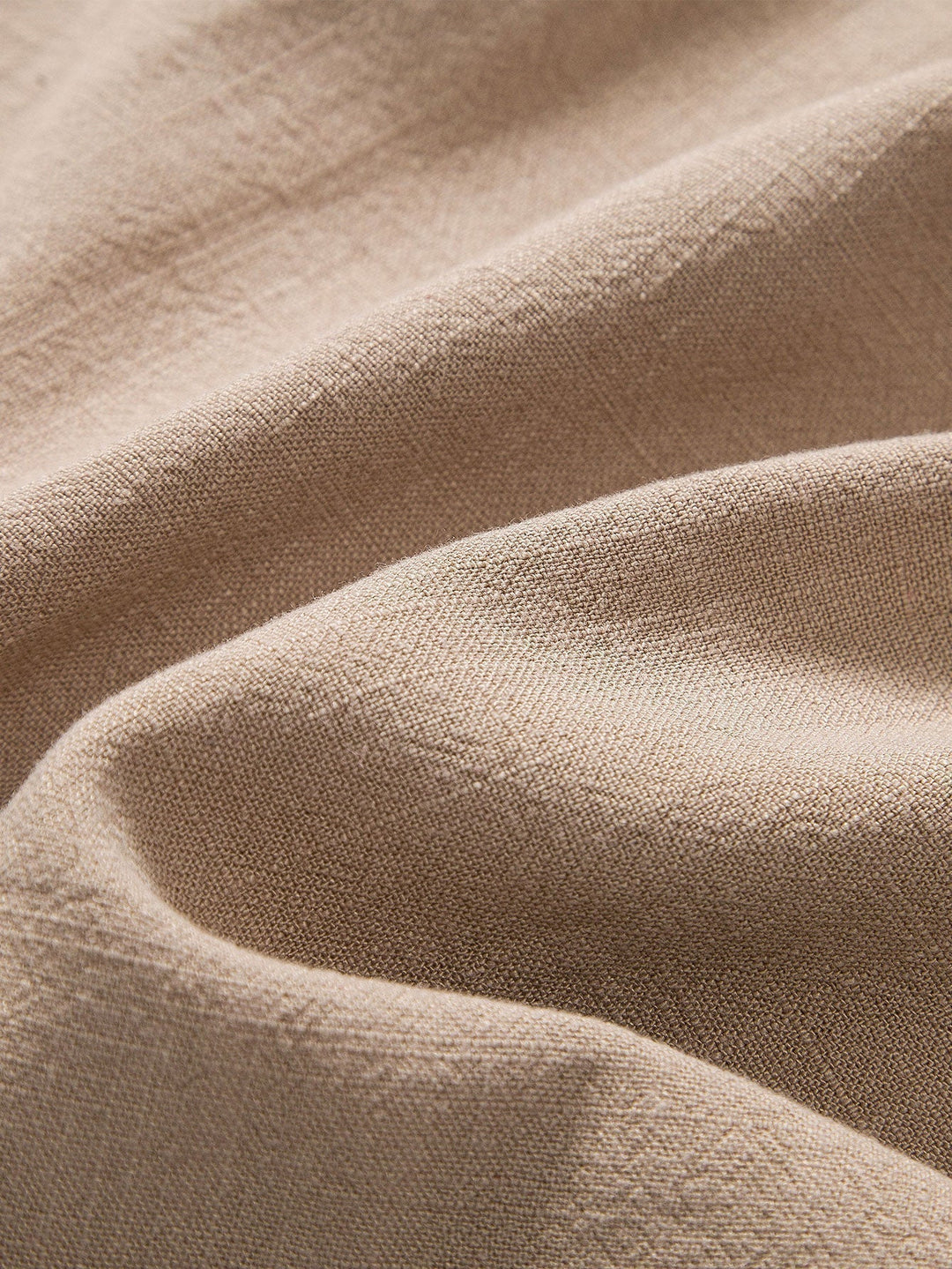 Zoom sur le tissu beige de haute qualité, offrant une texture douce et légère, idéale pour un confort optimal pendant l'été. Parfait pour une tenue élégante et décontractée.