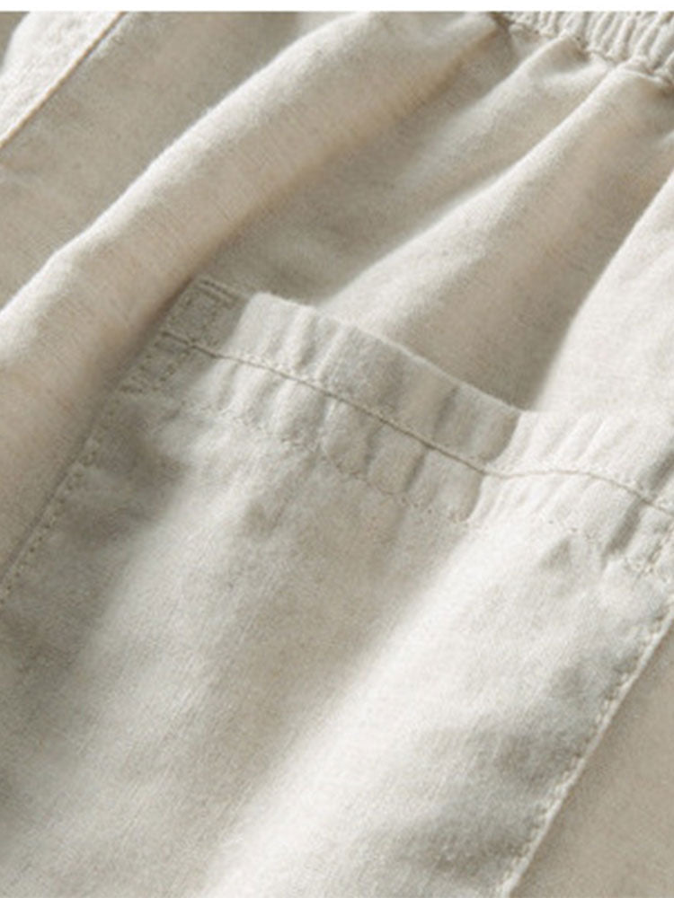 Détail du pantalon beige clair, mettant en valeur les poches latérales et la taille élastique, offrant à la fois confort et praticité pour un look décontracté.