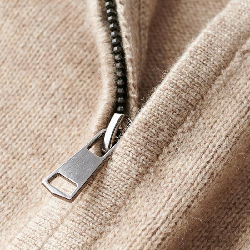Gros plan du pull zippé pour hommes Basile, en maille beige, mettant en valeur la fermeture éclair métallique et la texture douce du tissu.
