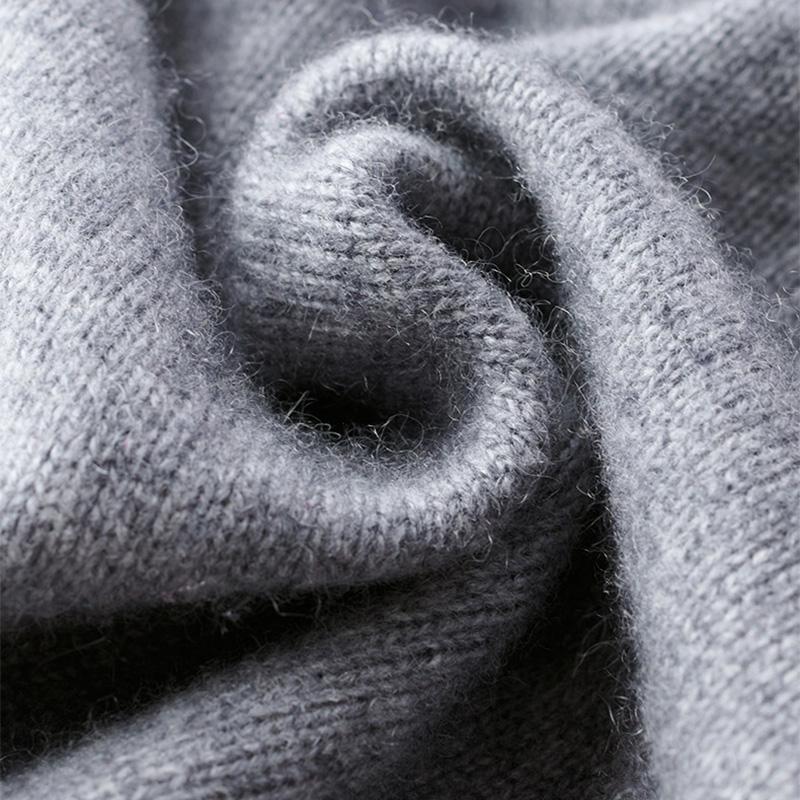 Gros plan sur la maille douce et épaisse du pull zippé pour hommes Basile en gris, mettant en valeur la texture chaude et moelleuse du tissu.