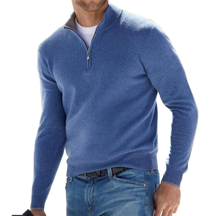 Homme portant le pull zippé pour hommes Basile en maille bleu chiné, coupe moderne avec col montant et demi-zip, porté avec un jean pour un style décontracté chic.