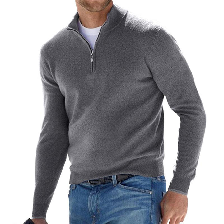 Homme portant le pull zippé pour hommes Basile en maille grise, coupe moderne avec col montant et demi-zip, porté avec un jean pour un style casual chic.