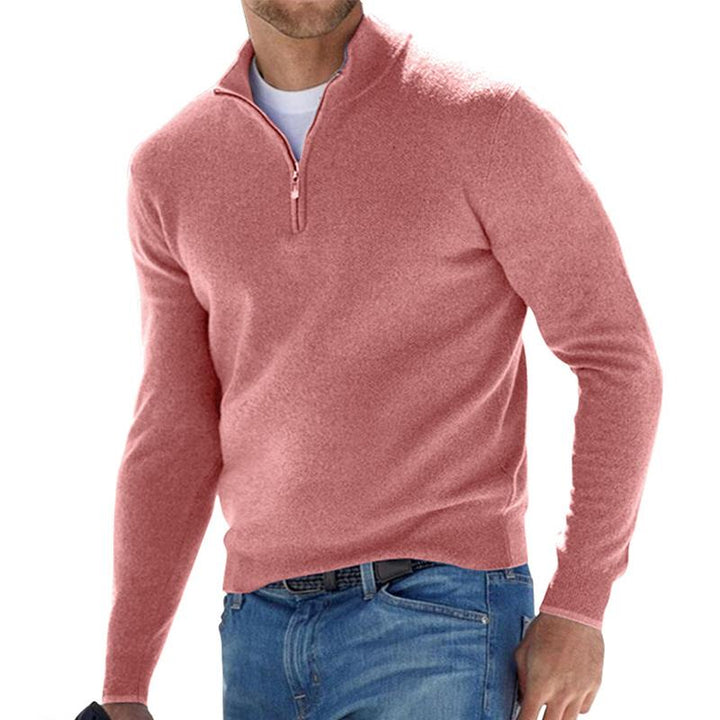 Homme portant le pull zippé pour hommes Basile en maille rose poudré, coupe moderne avec col montant et demi-zip, associé à un jean pour un look casual chic.
