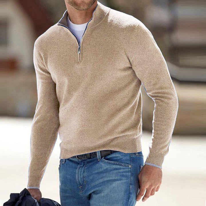 Homme portant le pull zippé pour hommes Basile en maille beige sable, coupe moderne avec col montant et demi-zip, associé à un jean pour un look casual chic.