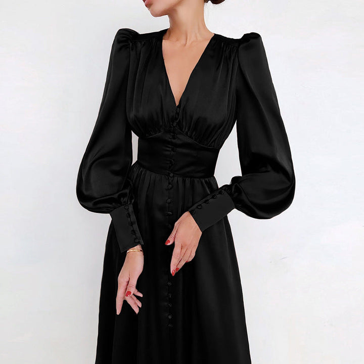 Une femme portant une chic robe en satin noir avec des manches longues bouffantes et des détails de boutons sur le devant. La robe présente un décolleté en V flatteur et une taille cintrée, lui conférant un look intemporel et élégant, parfait pour un événement sophistiqué en soirée.