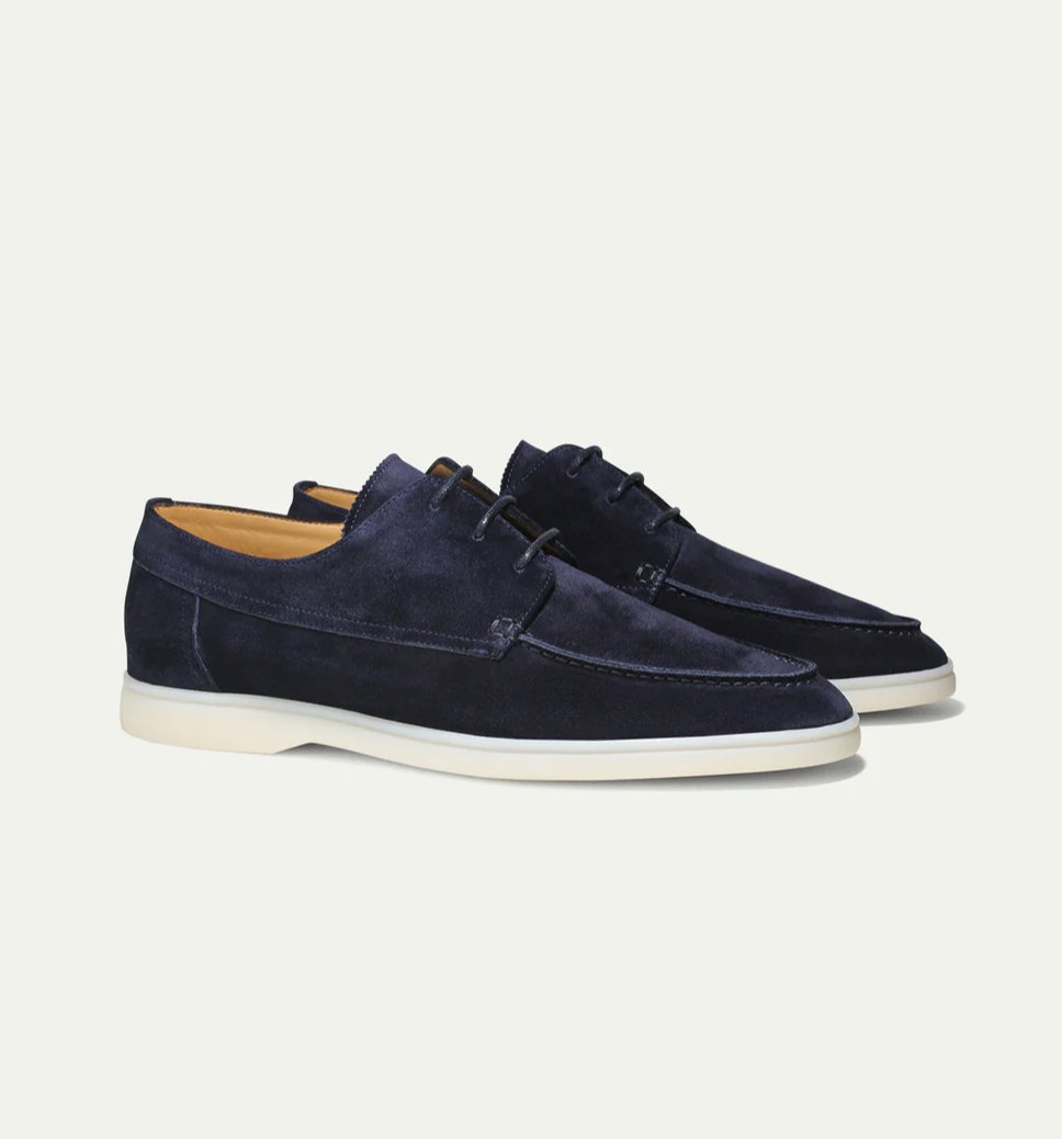 Mocassins classiques pour hommes Boniface en daim bleu marine, avec lacets et semelle claire, présentés en paire sur fond blanc.