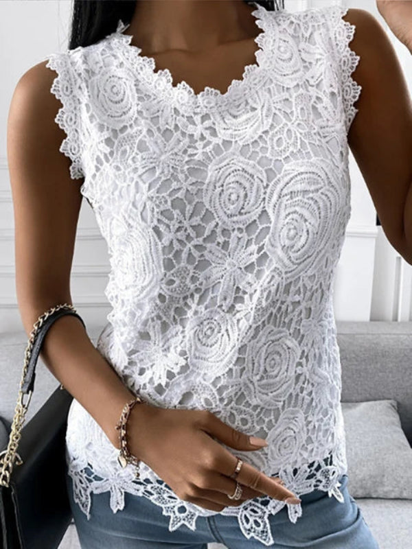 Top femme blanc en dentelle florale, sans manches avec encolure en V festonnée et ourlet ajouré, porté avec un jean.
