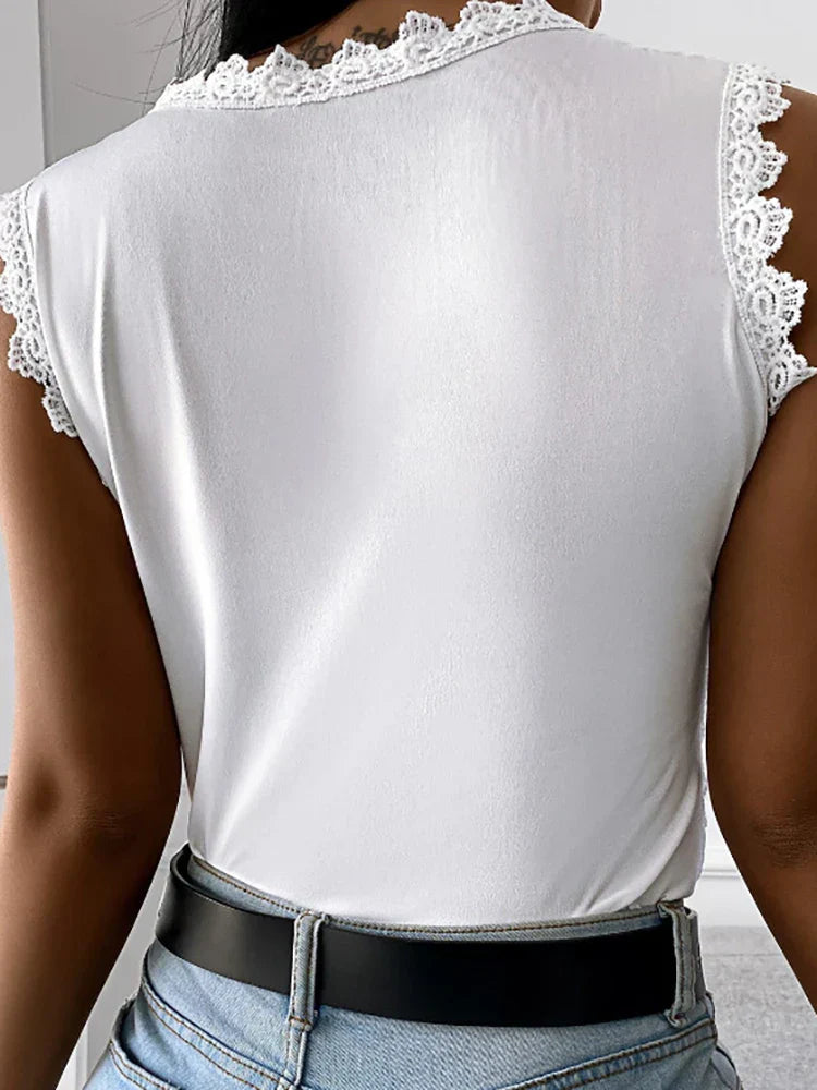 Vue de dos d’un top femme blanc à manches courtes avec bordures en dentelle, porté avec un jean et une ceinture noire.
