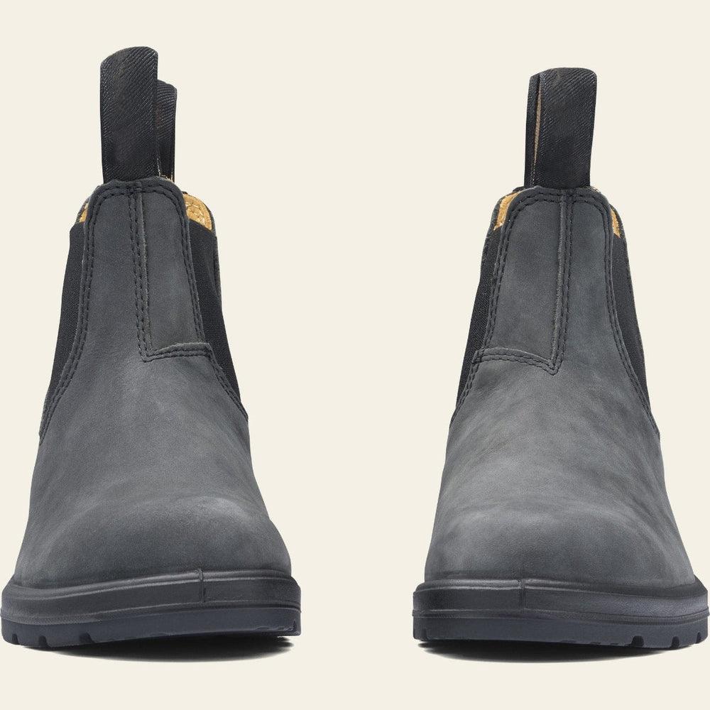 Paire de bottines en cuir noir à enfiler, au design minimaliste avec élastiques latéraux et languettes de tirage, posées sur une semelle épaisse antidérapante. Ces chaussures offrent un style chic et durable, parfait pour les tenues d’automne ou d’hiver.