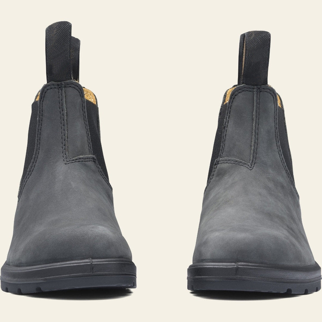 Paire de bottines en cuir noir à enfiler, au design minimaliste avec élastiques latéraux et languettes de tirage, posées sur une semelle épaisse antidérapante. Ces chaussures offrent un style chic et durable, parfait pour les tenues d’automne ou d’hiver.