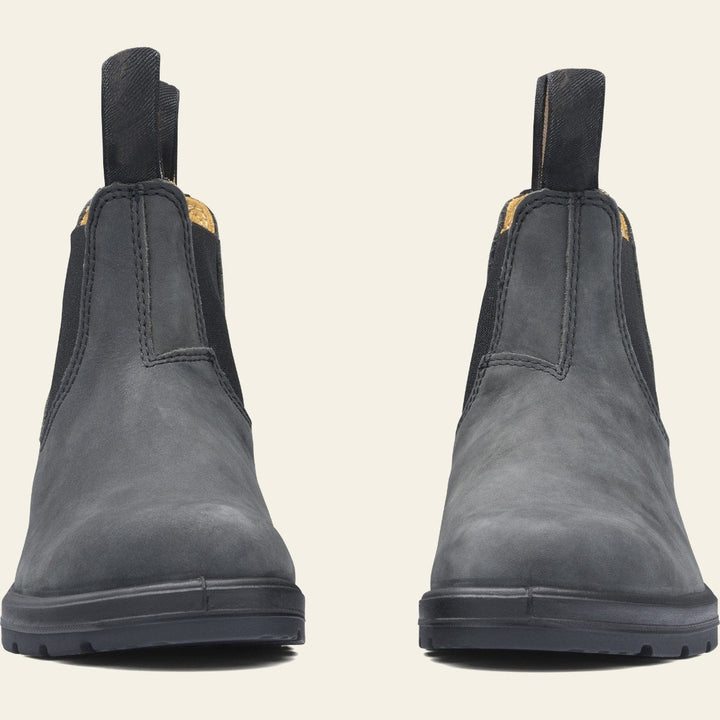 Paire de bottines en cuir noir à enfiler, au design minimaliste avec élastiques latéraux et languettes de tirage, posées sur une semelle épaisse antidérapante. Ces chaussures offrent un style chic et durable, parfait pour les tenues d’automne ou d’hiver.